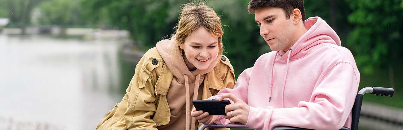 Couple looks at mobile phone outdoors