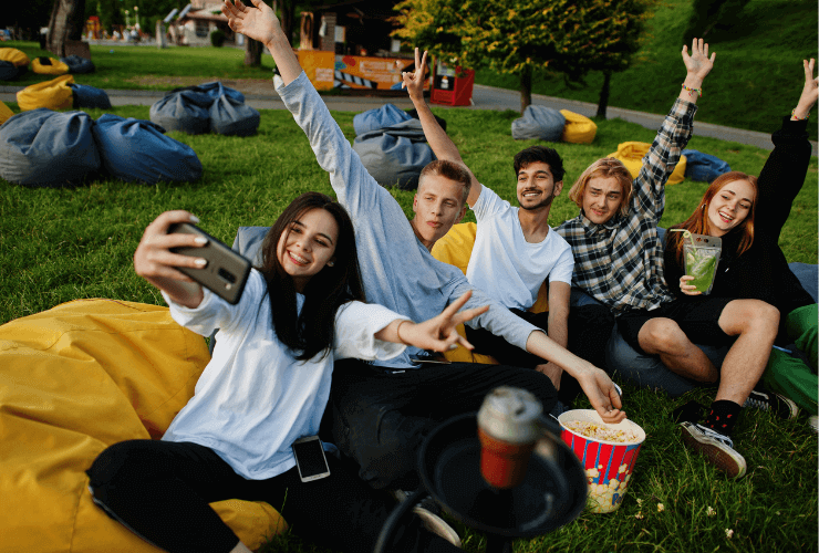 Kids taking a picture on a cell phone in the park