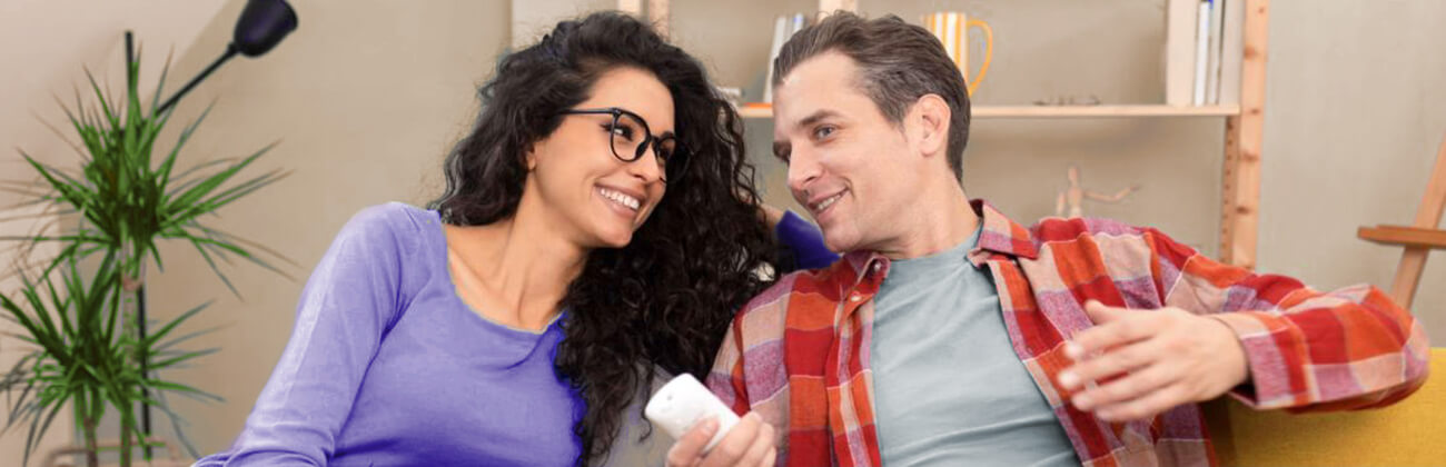 couple watching HDTV with remote control in hand