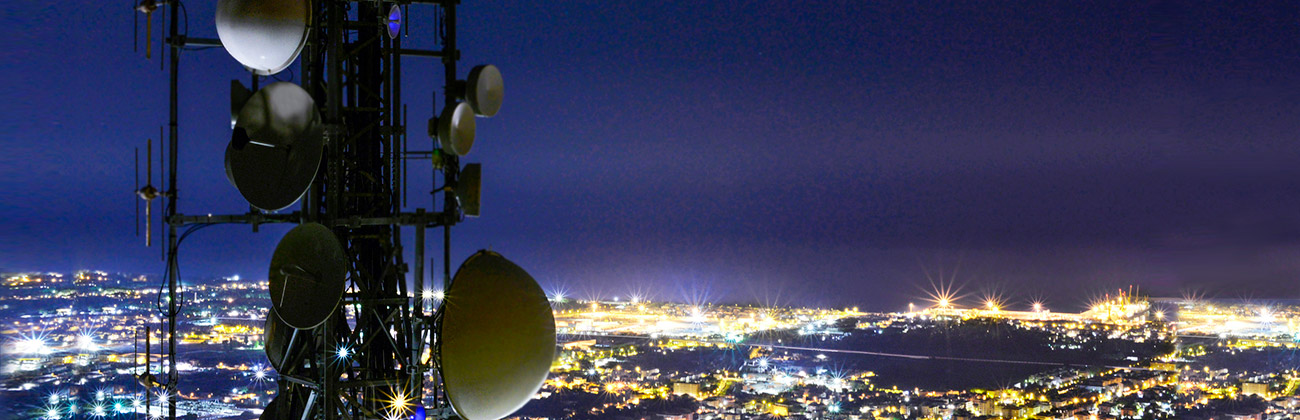 5G towers over city landscape at night