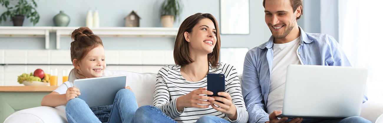 Family on couch each on their own device