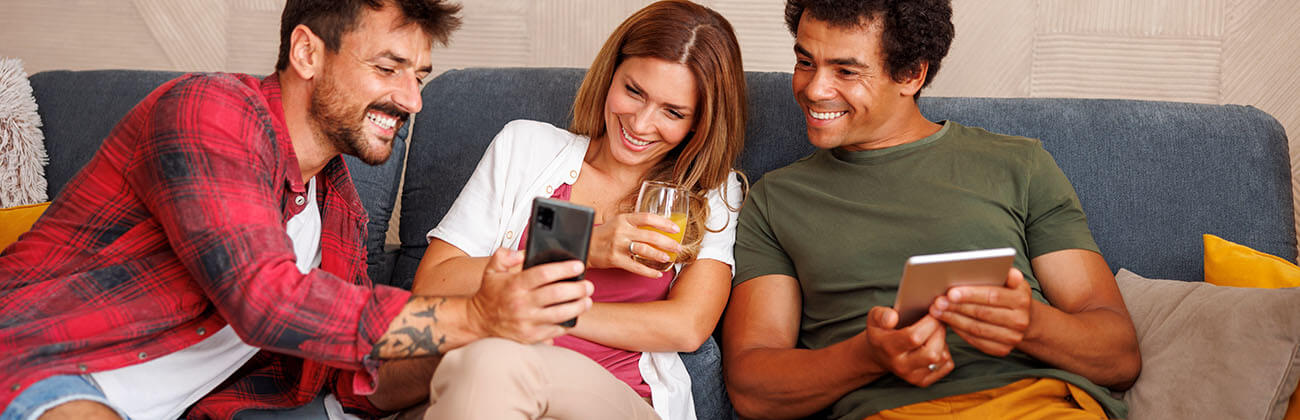 Friends on a couch use their WiFi devices