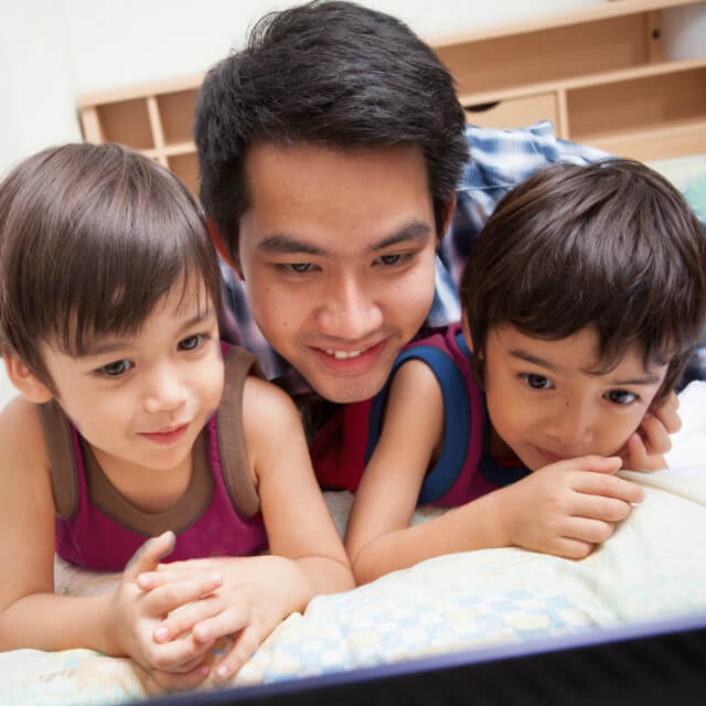 dad and kids streaming on laptop